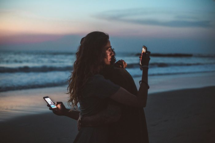 A couple checking their social media accounts on their phones.